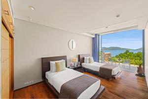 a bedroom with two beds and a view of the ocean at Villa Hale Malia in Kathu