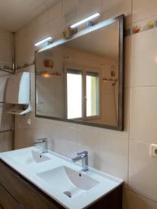 a bathroom with two sinks and a large mirror at Vue panoramique & jacuzzi privé in Saint-Hilaire