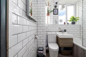 a white bathroom with a toilet and a sink at GuestReady - A Perfect Retreat in Dalston in London