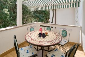 a table and chairs sitting on a porch with a table and a table at Apartmani Biserka in Mandre