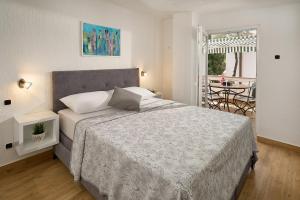 a bedroom with a bed and a balcony with a table at Apartmani Biserka in Mandre