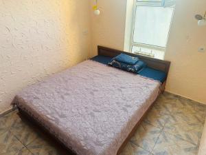 a small bedroom with a bed with a purse on it at Sweet Home Hostel in Bishkek