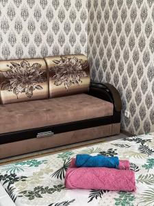 un sofá con 2 almohadas en el suelo en una habitación en ЖК Нектар, en Aktobe