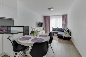 a kitchen and a living room with a table and chairs at 4 Oceany by Grand Apartments in Gdańsk