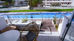 a balcony with chairs and a swimming pool at Coral Ocean View - Adults Only in Playa de las Americas