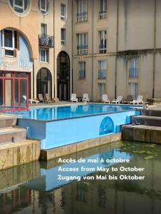 a swimming pool in front of a building at Romantique "comme à Venise" au bord de l'eau avec parking in Metz