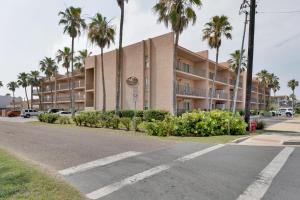 an empty street in front of a building with palm trees at Beachfront convenience w/o the beachfront price! in South Padre Island