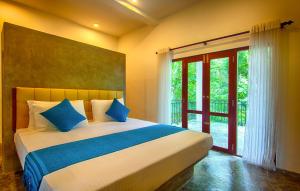 a bedroom with a large bed and a sliding glass door at Wild Nest Villa Unawatuna in Unawatuna