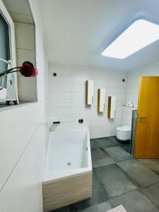 a white bathroom with a sink and a toilet at Villa Stefaner in Kirchbach