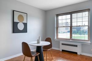 a white room with a table and chairs and a window at Evanston 1br w courtyard wd nr beach CHI-955 in Evanston