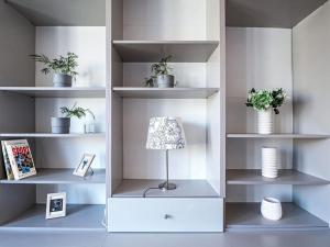 a room with white shelves with plants and a lamp at Shiny Buda Studio in Budapest