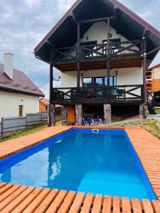 a house with a swimming pool in front of a house at Belvedere-Karpaty in Skhidnitsa