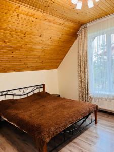 a bedroom with a bed with a wooden ceiling at Belvedere-Karpaty in Skhidnitsa