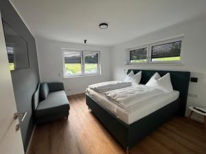 um quarto com uma cama, uma cadeira e janelas em Villa Turnersee em Obersammelsdorf