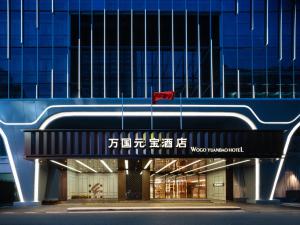 Guangzhou Wogo Yuanbao Hotel - Zhujiang New Town في قوانغتشو: مبنى امامه علم