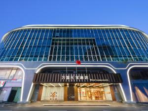 een hoog gebouw met een winkel ervoor bij Guangzhou Wogo Yuanbao Hotel - Zhujiang New Town in Guangzhou