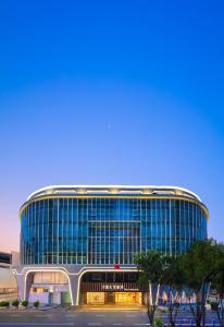 広州市にあるGuangzhou Wogo Yuanbao Hotel-Zhujiang New Town-Free Canton Fair Shuttle Bus & Overseas Buyer Registration Servicesの大きな窓のある大きな建物