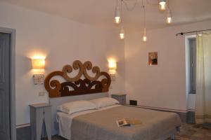 a bedroom with a large bed with a wooden headboard at Bisos in Paulilatino