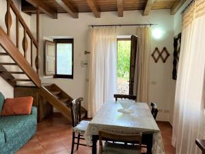 a dining room with a table and a green couch at Casa Didime, al centro di Malfa a soli 600 mt dalla spiaggia in Malfa