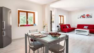 a living room with a table and a red couch at Casa di Elena in Iglesias