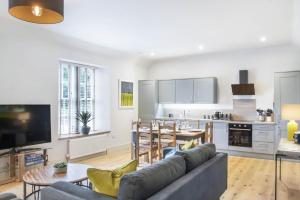The Woodside Apartments في Doune: مطبخ وغرفة معيشة مع أريكة وطاولة