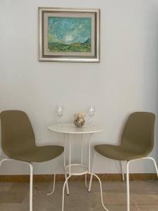 a table and two chairs with wine glasses on it at Nuovi bilocali Panta Rei - Suite della Terra in Senigallia