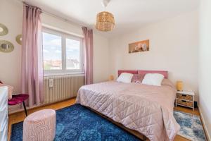 - une chambre avec un lit et une grande fenêtre dans l'établissement L'Adeline - Charmant appartement, à Lingolsheim