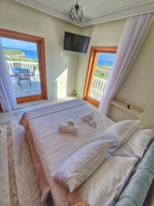 a bedroom with a large bed with two towels on it at Majestic View Resort in Nafpaktos