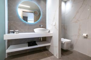 a bathroom with a sink and a mirror and a toilet at GRAND PATELLI in Myrina