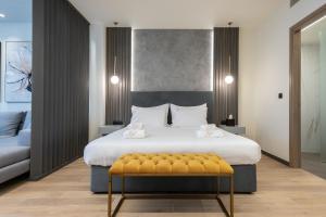 a bedroom with a large bed with a yellow bench at GRAND PATELLI in Myrina