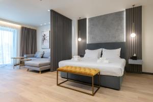 a bedroom with a bed and a chair and a couch at GRAND PATELLI in Myrina