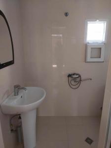 a white bathroom with a sink and a window at Guest House GioRgi in Kobuleti