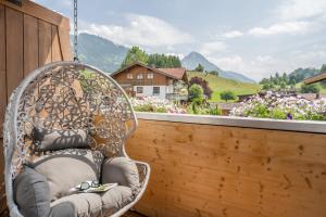 een rieten stoel op een balkon met uitzicht bij bichl 761 in Fischen