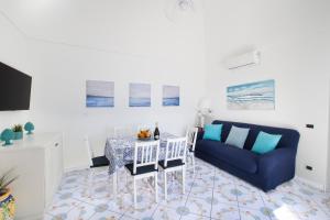 salon ze stołem i niebieską kanapą w obiekcie Estate4home - Casa Darly w mieście Positano