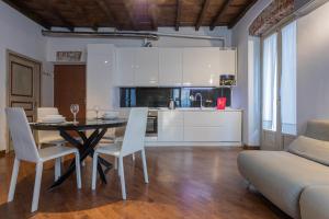 kuchnia i jadalnia ze stołem i krzesłami w obiekcie Elegante appartamento al Quadrilatero by Wonderful Italy w Turynie