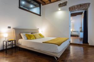 a bedroom with a bed with yellow pillows on it at Elegante appartamento al Quadrilatero by Wonderful Italy in Turin