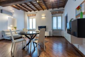 comedor y sala de estar con mesa y sillas en Elegante appartamento al Quadrilatero by Wonderful Italy, en Turín