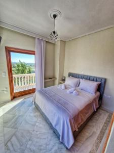 a bedroom with a large bed and a large window at Majestic View Resort in Nafpaktos
