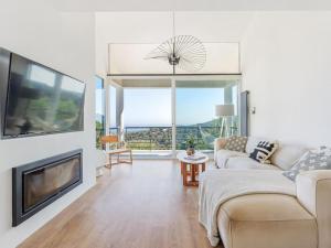 a living room with a couch and a flat screen tv at Villa Alella Panoramic Views in Alella