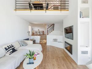 een woonkamer met een witte bank en een tafel bij Villa Alella Panoramic Views in Alella