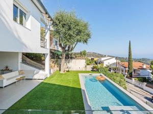 a backyard with a swimming pool and a lawn at Villa Alella Panoramic Views in Alella