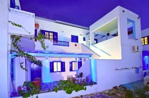a white house with blue doors and windows at night at moments rooms in Adamas