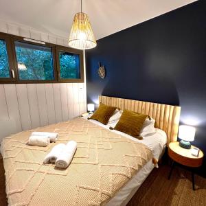 een slaapkamer met een bed met twee handdoeken erop bij La Villa du Lac - piscine chauffée - Jacuzzi - clim in La Teste-de-Buch
