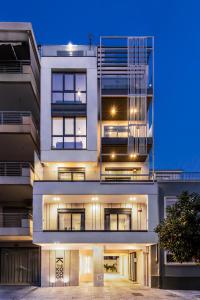 een groot wit gebouw met verlichting aan bij The Kokoon Volos Comfort Living in Volos