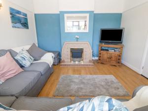 a living room with a couch and a tv at Awelfryn in Holyhead