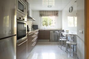 a kitchen with stainless steel appliances and a table at Centric apartment gran via fira montjuic in Hospitalet de Llobregat
