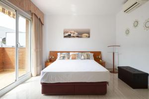 a bedroom with a large bed and a large window at Centric apartment gran via fira montjuic in Hospitalet de Llobregat