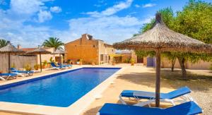 una villa con piscina con sillas y sombrilla en Ses Salines, 4409-56 Mallorca - Ses Puntes-, en Ses Salines