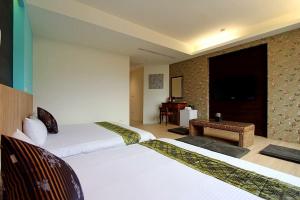Habitación de hotel con 2 camas y mesa en 開心居-正市中心電梯民宿-步行東大夜市5分鐘 en Hualien