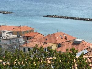 un groupe de maisons au toit rouge près de l'eau dans l'établissement Dolcevita Holiday, à Arma di Taggia